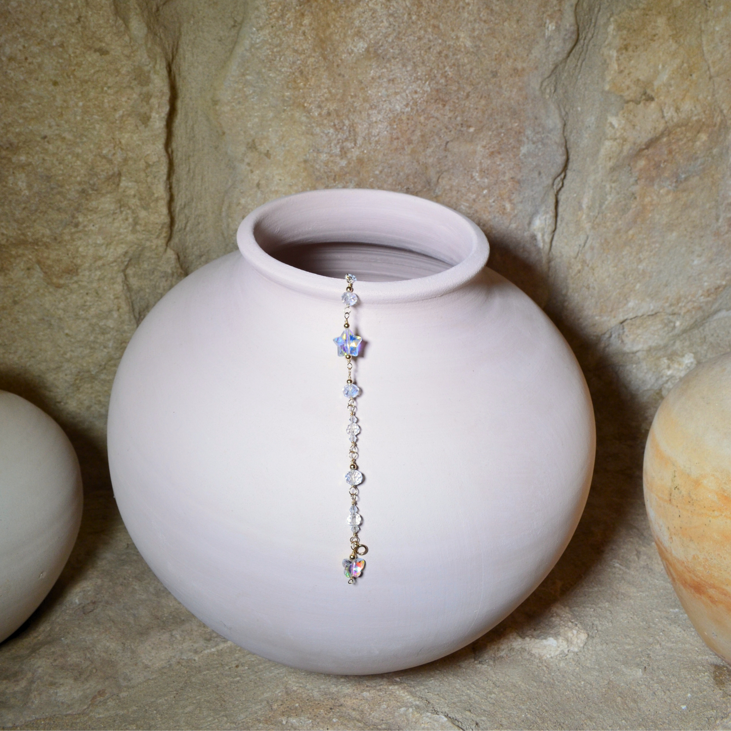 Handcrafted April birthstone bracelet featuring 14k gold-filled materials, radiant glass crystals, and a dangling butterfly and star crystal, displayed elegantly hanging in a ceramic vase. Perfect for gifting on birthdays, anniversaries, or special occasions, symbolising clarity, strength, and brilliance.