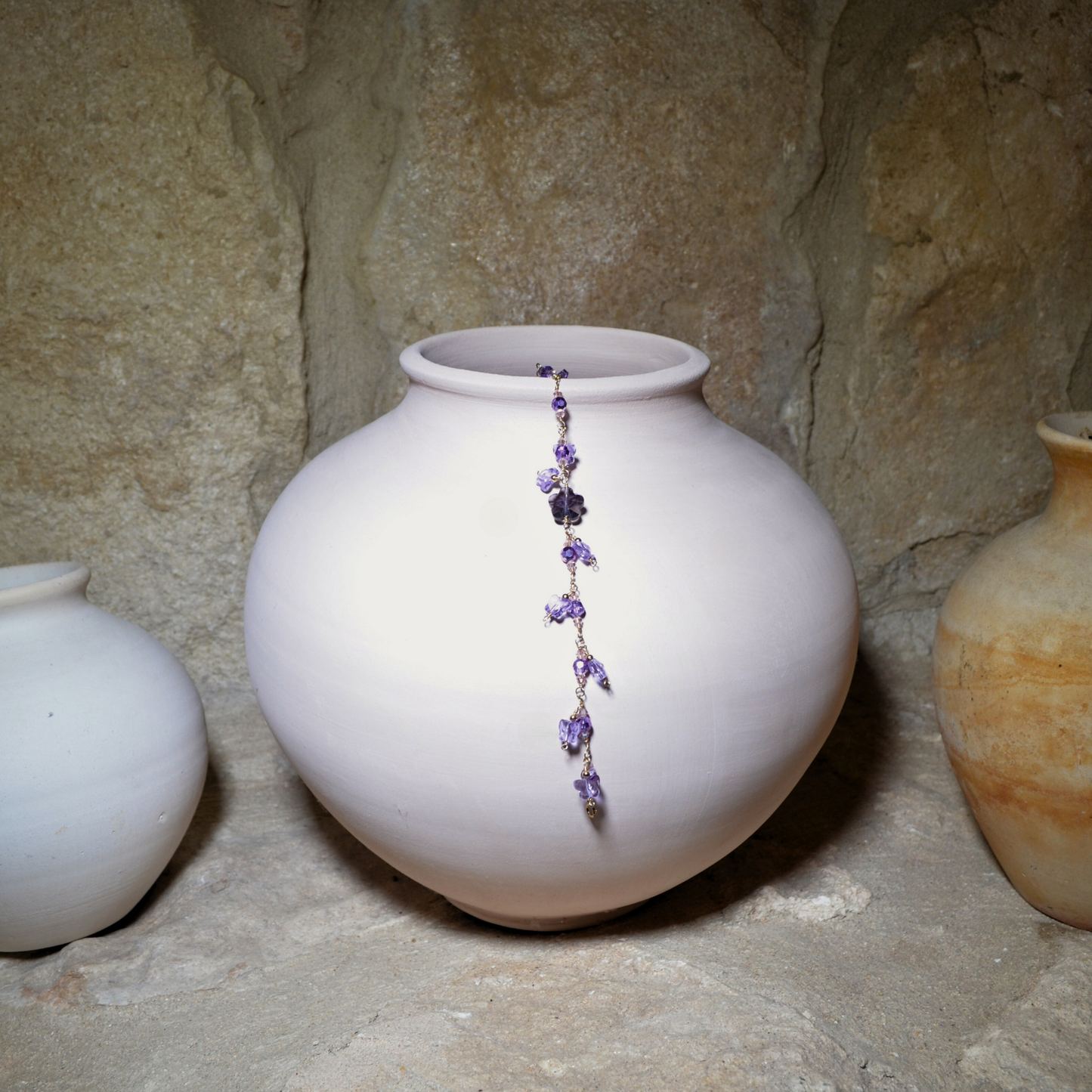 A beautiful handmade February amethyst-inspired purple crystal flower and butterfly crystal bracelet, handcrafted with a gold-filled chain displayed on a white ceramic vase. Perfect birthday gift, anniversary, valentines gift or for any occasions.